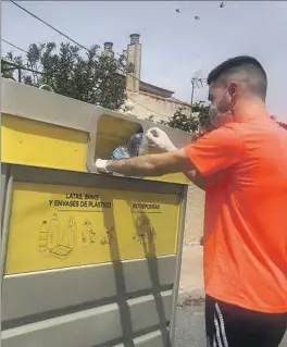  ?? ?? Un ciudadano reciclando una botella de plástico en un contenedor.