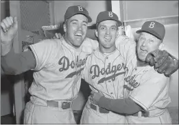  ?? THE ASSOCIATED PRESS, FILE ?? Brooklyn Dodgers pitcher Carl Erskine, center, celebrates with teammate Duke Snider, left, and manager Charley Dressen after beating the Yankees 6-5in Game 5of the World Series at Yankee Stadium in New York on Oct. 5, 1952. Erskine, who was a 20-game winner in 1953, died Tuesday. He was 97.