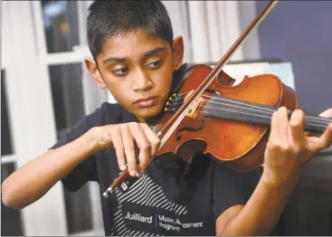  ?? Erik Trautmann / Hearst Connecticu­t Media ?? Arav Amin practices violin in the dining room of his home Tuesday in Norwalk. Amin, a Roton Middle School sixth-grader, attends the Juilliard Music Advancemen­t Program with other top musicians aged 8-17.