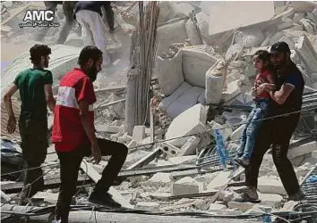  ?? AP ?? A man carries a girl out of the rubble of a destroyed building after barrel bombs were dropped on the Bab Al Nairab neighbourh­ood in Aleppo on Saturday.