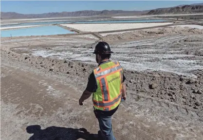  ?? CARLOS BARRIA/REUTERS FILE ?? An employee walks near lithium evaporatio­n ponds at Albemarle’s production facility in Silver Peak, Nev., in 2022. Nevada has the only commercial U.S. lithium operation.