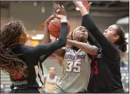  ?? (Photo courtesy UALR Athletics) ?? UALR forward Teal Battle (center) attempts to shoot as Arkansas State’s Morgan Wallace (left) and Talia Roldan defend during Saturday’s Sun Belt Conference game at the Jack Stephens Center in Little Rock. Battle finished with 25 points and 11 rebounds in the Trojans’ 60-56 victory over the Red Wolves in overtime.