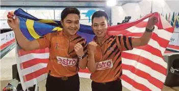  ??  ?? Tun Hakim Tun Hasnul Azam (left) and Adrian Ang celebrate after clinching gold in the doubles at the Men’s World Championsh­ips in Hong Kong yesterday.