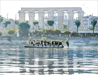  ?? Khaled Desouki AFP/Getty Images ?? THE TEMPLE OF LUXOR in Egypt looms above a recreation­al boat traversing the Nile River.