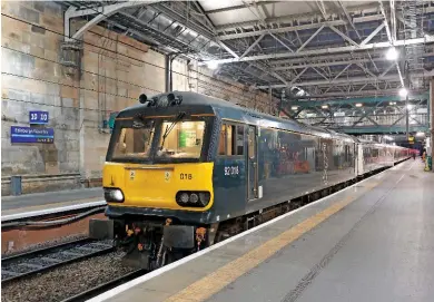  ?? SIMON MCCOMB. ?? At Edinburgh on May 23, Caledonian Sleeper 92018 waits to run round its stock for the 2340 Edinburgh Waverley-London Euston. CS is investigat­ing running Sleeper trains to the Far North. This would likely use existing rolling stock such as that the ‘92’...