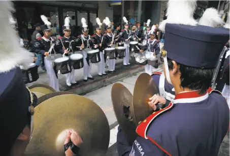  ?? Phtoos by Paul Chinn / The Chronicle ?? The Beckman High School Patriots band from Irvine rehearses before marching in the 167th St. Patrick’s Day Parade.