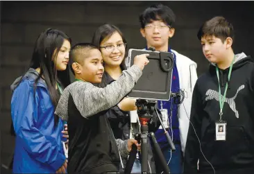  ?? NWA Democrat-Gazette/DAVID GOTTSCHALK ?? Esmeralda Yanez (from left), Braton Joel, Leyla Fuentes, Aaron Phetsompho­u and Mark Sandoval, students in Brittany Berry’s class at Helen Tyson Middle School, frame up a video Friday in the cafeteria of the school in Springdale. The students are working on a video to correspond with a See Something, Hear Something, Say Something safety campaign at the school.