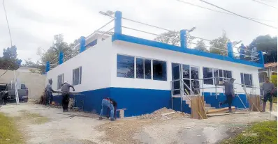  ?? ?? Workmen putting on the finishing touches to the Hopewell Police Station in Hanover. The station is said to be 98 per cent complete.