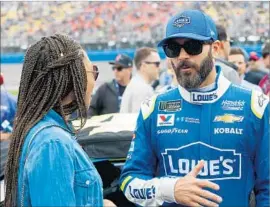  ?? Brian Lawdermilk Getty Images ?? JIMMIE JOHNSON, who finished 21st in the Auto Club 400, chats with Olympic track and field champion Allyson Felix at Auto Club Speedway in Fontana.