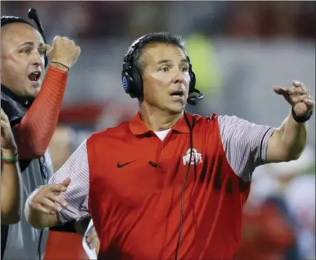  ?? SUE OGROCKI — THE ASSOCIATED PRESS FILE ?? In this file photo, Ohio State head coach Urban Meyer, right, and then-assistant coach Zach Smith, left, gesture from the sidelines during an NCAA college football game against Oklahoma in Norman, Okla. Ohio State expects to open fall camp as scheduled on Friday but without coach Urban Meyer.