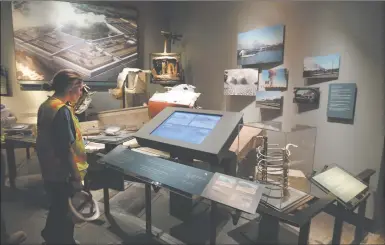  ?? AP PHOTO ?? A Port Authority of New York and New Jersey worker views a display of the attack on the Pentagon Wednesday at the National September 11 Memorial Museum in New York. The museum is a monument to how the Sept. 11 terror attacks shaped history, from its...