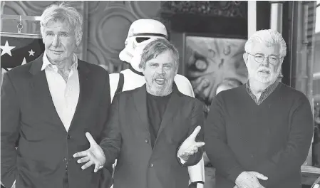  ?? MIKE NELSON/EPA-EFE ?? Mark Hamill is honored with a star on the Hollywood Walk of Fame with the help of Harrison Ford, left, and George Lucas.