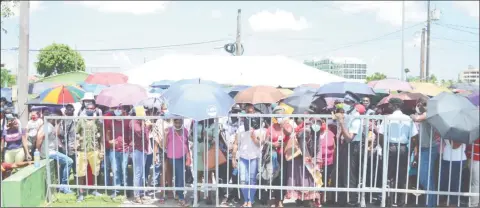  ?? (Photo by Orlando Charles) ?? A section of the crowd at the Providence Stadium presses against the barricades demanding to be allocated land