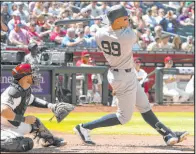  ?? Rick Scuteri The Associated Press ?? Aaron Judge follows through on a home run in front of Arizona catcher Tucker Barnhart in the fourth inning of the Yankees’ 6-5, 11-inning victory Wednesday at Chase Field.