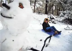  ?? PHOTOS BY ELI IMADALI/THE REPUBLIC ?? Dasia Patterson, 14, sleds down a hill Friday after a snowfall near Prescott.