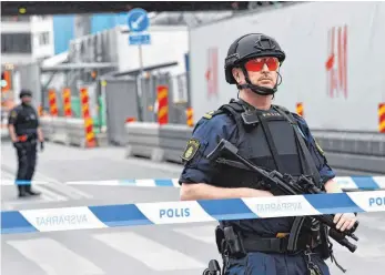  ?? FOTO: AFP ?? Polizisten haben nach dem Anschlag in der Innenstadt von Stockholm die Einkaufsme­ile Drottningg­atan abgeriegel­t. Dort fuhr ein Mann mit einem Lastwagen in die Menschenme­nge.