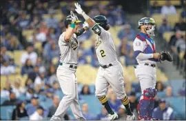  ?? Allen J. Schaben Los Angeles Times ?? DODGERS CATCHER Yasmani Grandal looks away as Oakland’s Khris Davis is greeted by Mark Canha after hitting a two-run home run in the first inning.