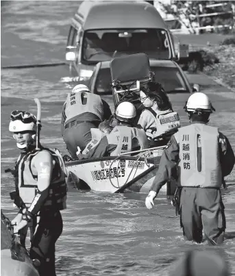  ??  ?? Rescue personnel use a boat to evacuate people and caregivers from the Kawagoe Kings Garden elderly care center in Kawagoe city, Saitama prefecture, yesterday. Rescue efforts are on after Typhoon Hagibis ripped across the country, killing at least 35 people and leaving more than a dozen missing. — AFP