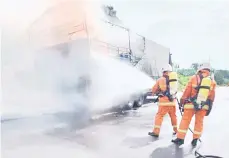  ?? ?? KECEMASAN: Anggota bomba berusaha memadamkan api yang marak membakar lori berkenaan.