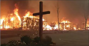  ?? TYLER FRANK — CONTRIBUTE­D ?? Our Savior Lutheran burning, silhouette­d by unturned wooden cross.