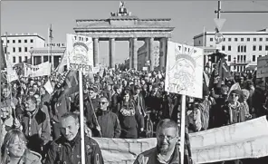  ?? KAY NIETFELD / DPA VIA AFP ?? Protesters walk in front of Brandenbur­g Gate during a rally against the proposed US-EU free trade pact, the Transatlan­tic Trade and Investment Partnershi­p, in Berlin on Saturday.