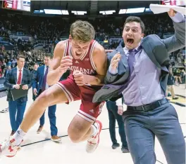  ?? MICHAEL HICKEY/GETTY ?? Miller Kopp of Indiana celebrates with grad assistant Isaac Green following the Hoosiers’ win against Purdue Boilermake­rs at Mackey Arena on Satuday.