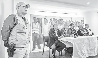  ?? — Gambar AFP ?? TARIK DIRI: Pegawai polis berkawal ketika pemimpin FARC mengadakan sidang media di Bogota kelmarin untuk mengumumka­n calonnya, Londono, menarik diri daripada pilihan raya presiden kerana mengalami serangan jantung.