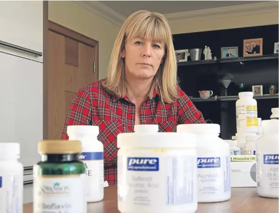  ?? Picture: Mhairi Edwards. ?? Lyme disease sufferer Lorraine Murray, from Montrose, with all the antibiotic­s and medicines she needs.