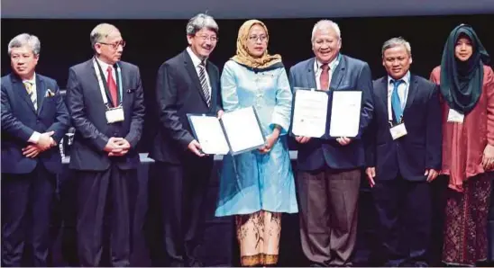  ?? [FOTO MOHAMAD SHAHRIL BADRI SAALI/BH] ?? Hamidah (tengah) menyaksika­n pertukaran memorandum persefaham­an antara Mohamed Ibrahim dan Rektor, Universita­s Pertamina, Prof Akhmaloka, pada majlis perasmian Kongres Kejurutera­an, Sains dan Teknologi 2018 di KLCC, semalam.