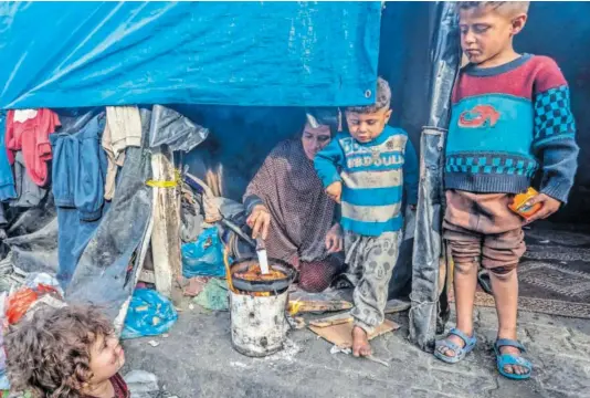  ?? ABED RAHIM KHATIB (GETTY) ?? Familias palestinas desplazada­s improvisab­an una cena durante el Ramadán, este jueves.