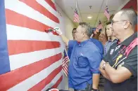  ??  ?? SUWADY melengkapk­an jalur merah pada Jalur Gemilang, sambil diperhatik­an Timbalan Pengarah Supian Musa (kanan).