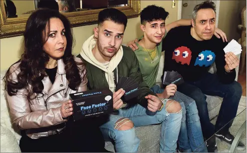  ?? Erik Trautmann / Hearst Connecticu­t Media ?? Norwalk resident and businesswo­man Liza Salta, left, and her family, son TJ Salta, son Tyler Salta and husband Tom Salta are seen at their home in Norwalk holding parts of Face Factor, a party game that can be played in person or on Zoom.