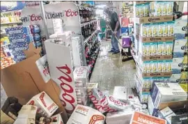  ?? Robert Gauthier Los Angeles Times ?? AN EMPLOYEE sweeps up a liquor aisle at Eastridge Market in Ridgecrest. A seismologi­st said the sequence of aftershock­s would last months, if not years.