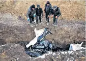  ?? ?? Bodies are put in a mass grave on the outskirts of Mariupol