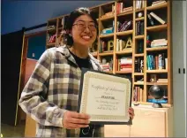  ?? Caleb Lunetta/The Signal ?? (Above) Jean Paik stands with the certificat­e she received after speaking at the first Santa Clarita World Speech Day event on Friday. (Below) Students participat­e in an activity for the event.