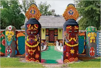  ?? BOB ANDRES / BANDRES@AJC.COM ?? Painted totems flank the entrance to Pasaquan, an art installati­on created by the late visionary artist Eddie Owens Martin.