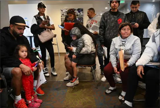  ?? HELEN H. RICHARDSON — THE DENVER POST ?? Venezuelan migrant Juan Carlos, left, takes care of his friend’s daughter Arantza Borges, 2, while they and other migrants wait in line to meet with Spanish-speaking volunteers to help them begin the work permitting process at a hotel in Denver on Feb. 5. Migrants coming to Denver from Venezuela had all sorts of careers in their native country, but getting work authorizat­ion in the U.S. can take six months or longer.