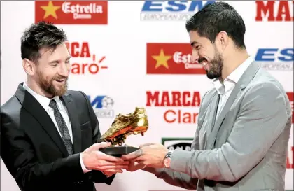  ??  ?? El argentino Lionel Messi recibe de manos de su compañero del FC Barcelona, el uruguayo Luis Suárez, la cuarta Bota de Oro en su carrera, galardón que lo acredita como máximo goleador de Europa ■ Foto Ap