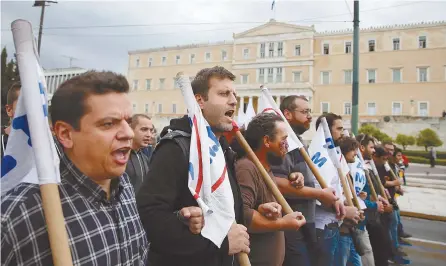  ?? Reuters-Yonhap ?? Members of the communist-affiliated PAME trade union shout slogans as they march past the parliament building during a demonstrat­ion marking a 24-hour general strike against the latest round of austerity Greece has agreed with its lenders, in Athens,...