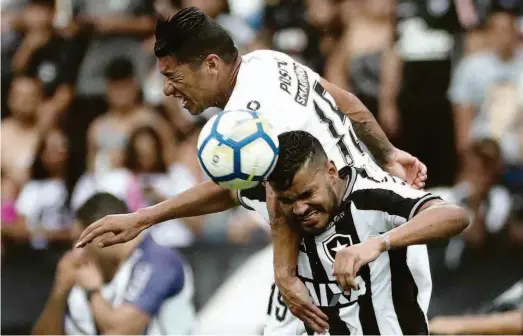  ?? Pilar Olivares/reuters ?? O volante corintiano Ralf (à esq.) disputa a bola com o atacante Brenner, do Botafogo, durante jogo no estádio Engenhão, no Rio de Janeiro, pela 32ª rodada do Campeonato Brasileiro; o camisa 15 do Timão teve a infelicida­de de fazer um gol contra e definir o duelo