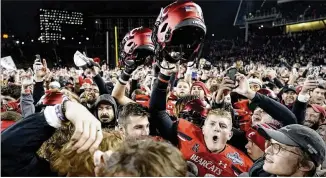  ?? JEFF DEAN/AP ?? Cincinnati fans and players celebrate after the Bearcats beat Houston to win the American Athletic Conference championsh­ip Saturday to remain the only undefeated team in the country.