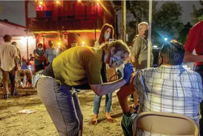  ?? Emily Kask / New York Times ?? People are vaccinated outside a live music venue April 9 in New Orleans. President Joe Biden urged all employers to offer full pay to their workers for time off to be inoculated and to recover from any aftereffec­ts.