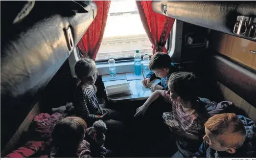  ?? ROMAN PILIPEY / EFE ?? Niños huérfanos huidos de la ciudad de Polohy tras la invasión rusa, esperan en el vagón de un tren de evacuación antes de partir hacia el oeste de Ucrania.