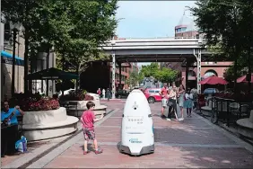  ?? MARVIN JOSEPH/WASHINGTON POST ?? This security robot patrols the pedestrian breezeway of Washington Harbour in Washington, D.C., in September. Its predecesso­r “drowned” in a fountain over the summer. A model in the San Francisco Bay Area’s pilot program was shut down following some...