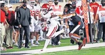  ??  ?? OU running back Rhamondre Stevenson steps out of bounds under pressure from Texas Tech linebacker Kosi Eldridge during the first half of a 62-28 win Saturday in Lubbock, Texas. [AP PHOTO/MARK ROGERS]