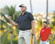  ?? Tim Bradbury / Getty Images ?? Patton Kizzire, with playoff rival James Hahn in the background, reacts after making par on the sixth extra hole.