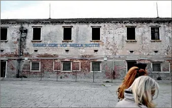  ?? PHOTO: AFP ?? A sign reads “we are with you in the night” at the Giudecca Women’s Prison hosting the Holy See pavilion of the 60th Venice Biennale art show in Venice.