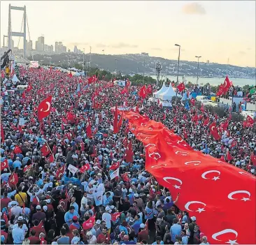  ?? [ APA ] ?? Unter einer Flagge: Zehntausen­de gedachten an der Istanbuler Bosporusbr­ücke des Putschvers­uchs.