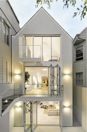  ?? Cesar Rubio ?? Top left: Designer lights are suspended from the ceiling beside the turned staircase in this Vallejo Street home. Top right: This home on Belvedere Street in Ashbury Heights offers outdoor spaces on all three levels. Collapsibl­e glass walls on the main...