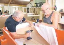  ?? ?? Members of the coffin club working on coffins during a work day at the Coffin Club’s workshop in Hastings.